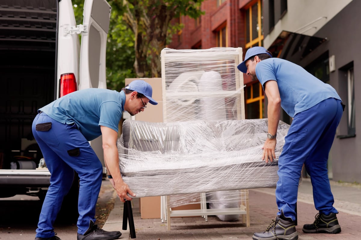 Professional Movers Outside Delivering Furniture Removal Service With Truck And Van.